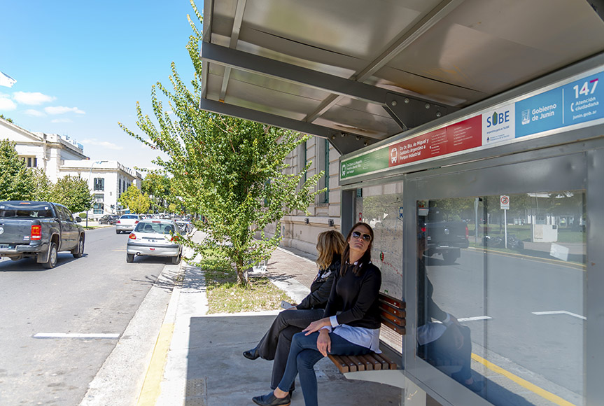 En la imagen se observa una foto de personas en el refugio del transporte publico urbano